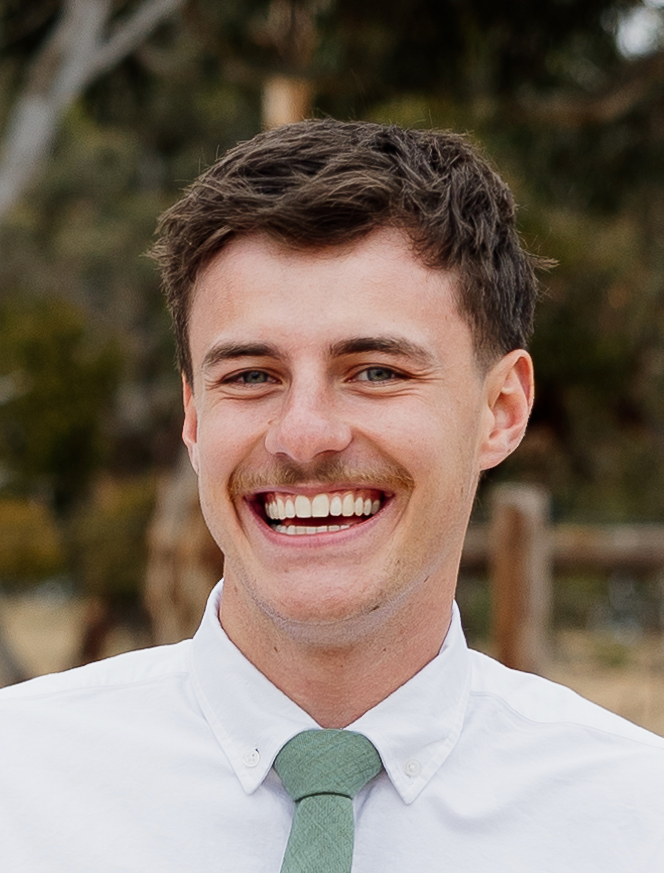 Reece White, founder of Reedys Agency, smiling in a white shirt and green tie